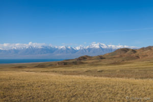 Dirt road leading to Uvs Lake and snowcapped Mountains, Mongolia