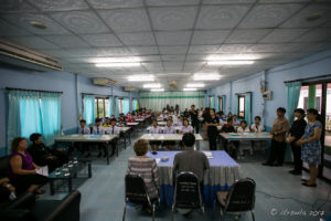 Fluorescent-lit Department of Education Office with students waiting at tables, Mae Sariang Thailand