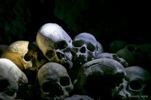 Piles of human skulls in the dark, Skull Cave, Milne Bay, PNG