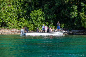 Dinghy landing tourists at Skull Cave on Milne Bay, PNG