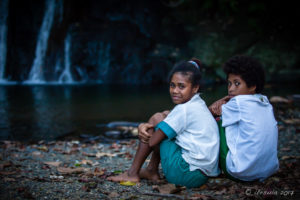 Papuan girls in school uniform at the Hewiia Waterfall, Milne Bay PNG