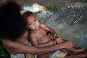 Baby in on mother's lap, Milne Bay, PNG