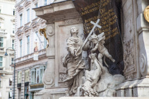 Marble sculpture: man with a cross, cherub, Vienna street, Austria