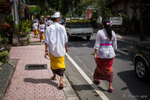 Balinese man and woman walking home from temple, Ubud