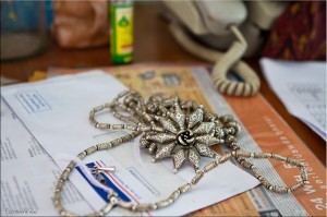 Close-up of fine silver jewellery on a littered table