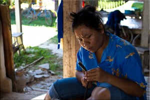 Thai woman hand-working silver in open-air basement
