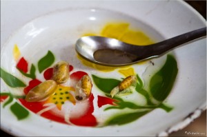 Cooked silkworms in a bowl with a spoon