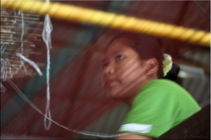 Young woman's face through the weft threads
