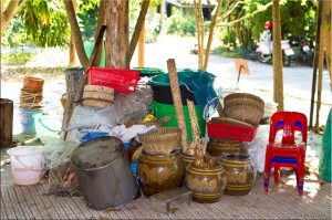 Clay pots and brooms under a tree