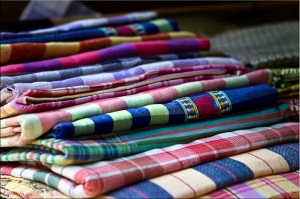 A pile of colourfully woven cotton cloths