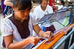 Thai women tying thread around silk for tie-dying