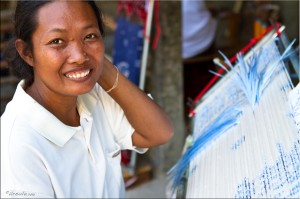 Smiling Thai woman with tied silk threads on a frame