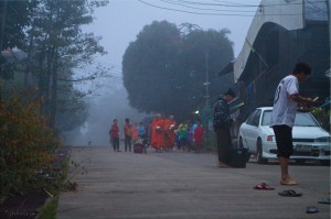Monks on alms rounds on a foggy street