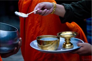 Close-up of woman dishing rice into monk bowl