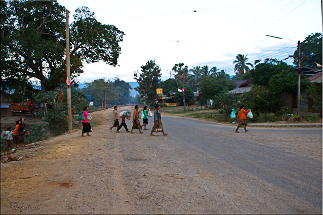 Lao people crossing a dusty road in Attapeu