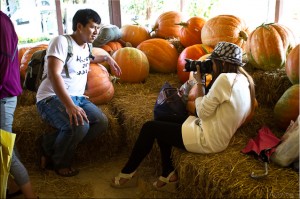 Thai woman photographing a Thai male amongst pumpkins