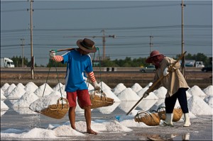 Thai man and woman moving salt
