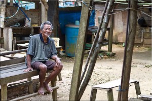 Old Indonesian man sitting outdoors