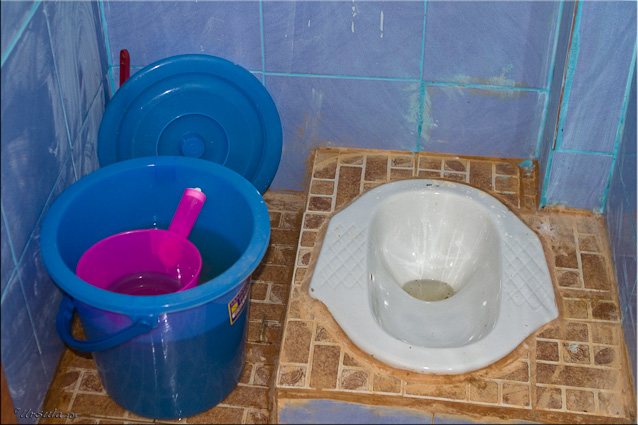 Squat toilet with blue water pail