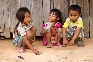 Three young Oye children playing in the dirt