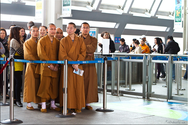 Monks in brown robes waiting in line