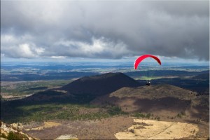 Red Parasail against the Auvergne volcanoes and grey cloud