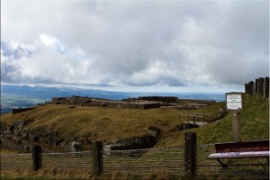 Fenced-in ruins under a grey sky