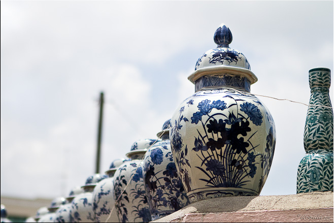 Large blue and white ceramic pots against a blue and white sky