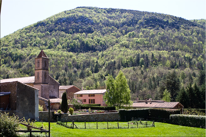 View of Sougraine church and village against a forested mountain