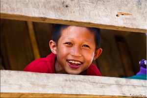 Karen boy smiling between wooden rails