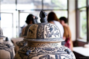 Foreground: blue and white greenware. Background: women shopping.