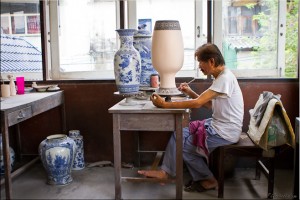 Man at a work-table underglazing blue and white pottery