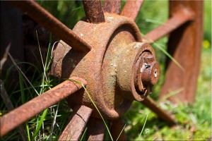 Rusty wheel axle in the grass