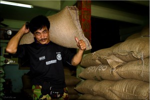 Thai man hoisting 50 pound hessian sack
