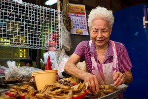 White haired lady sorting fried chicken wings
