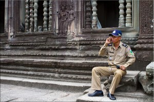 Man in brown uniform, on the phone, Angkor Wat