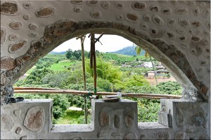 View through mushroom shaped window to cultivated fields and old village, Shandicun, Pai