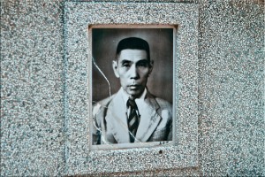Photo of a middle-aged man on a stone tomb ~ Chinese Graveyard