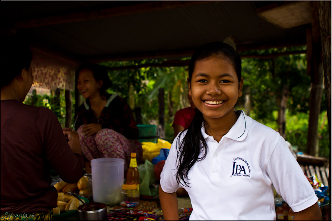 Portrait: Adolescent Khmer girl in her white school uniform polo shirt.