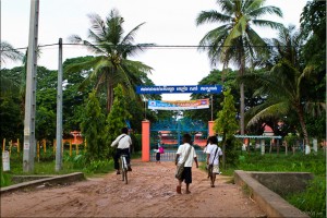 Children in school uniform walk and cycle to the gates of Sandan School, Cambodia