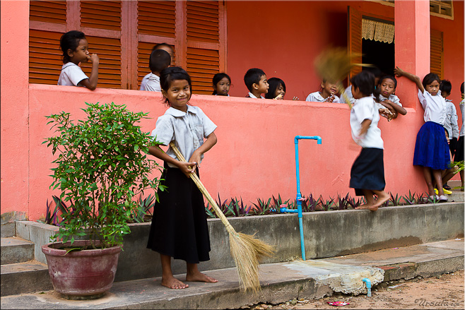 Young khmer girl in school uniform with a straw broom.