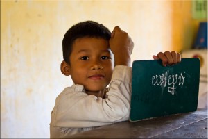 Portrait: Young Khmer boy with his green chalk-board