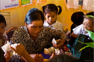 First-grade khmer children giving their teacher reals for their classroom tests.