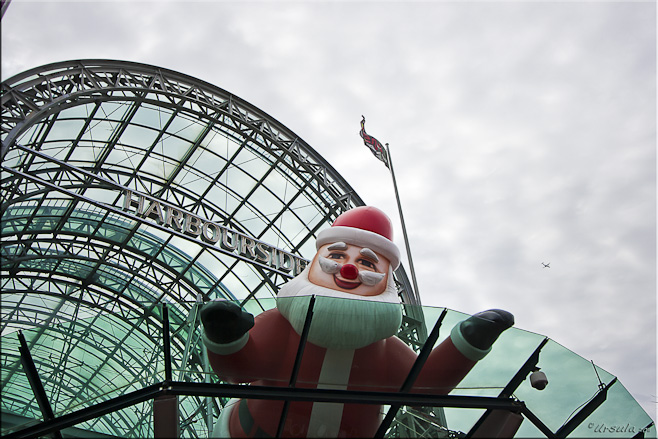 Large blow-up santa on a glass roof: Harbourside Darling Harbour, Sydney