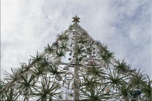 LED Christmas tree against a cloudy sky.