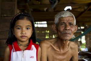 Portrait: Solemn Faced Khmer Girl and elderly white-haired man