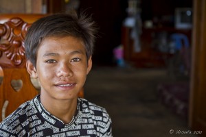 Portrait: Smiling, bright-eyed pimple-faced adolescent khmer boy