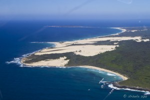 Aerial view of the blue waters of the Tasman Sea, and the white sands and green forests of Nadgee Nature Reserve.
