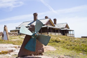 Ship's prop mounted on stone; Australian homestead behind.
