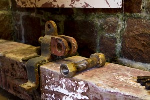 Close-up: old nuts and bolts on an old turned timber post.